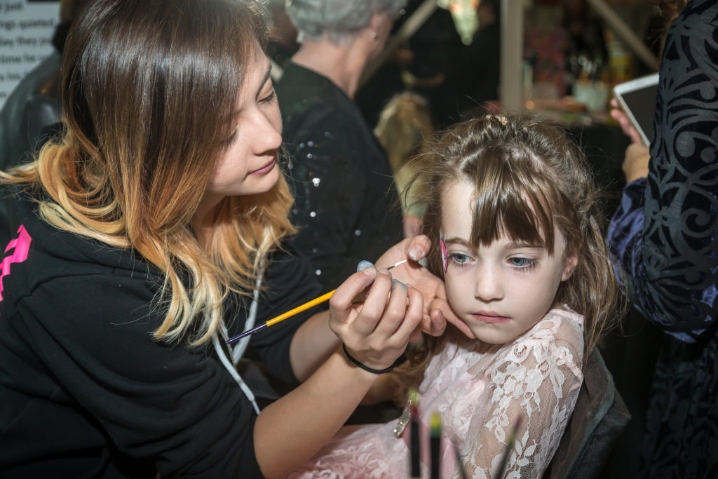 Clara Buckner getting her face painted by Sister Act Face Painting at the 2016 Sugar Plum Fairy Children's Ball